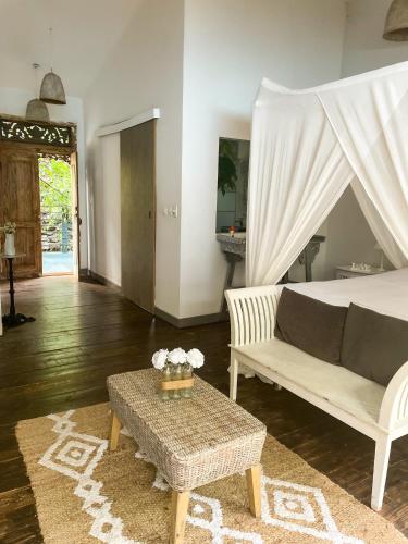 a living room with a bed and a table at Chambres d'hôtes & spa Le Jardin de Ravintsara in Ravine des Cabris