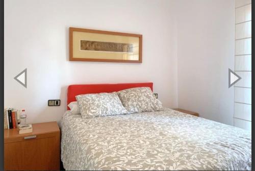 um quarto com uma cama e uma fotografia na parede em Apartamento con terraza en 1ª linea lateral a mar em Calafell