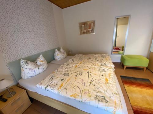 Un dormitorio con una cama con una colcha floral. en Gästehaus Schmitt, en Appenheim