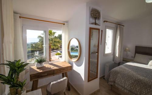 a bedroom with a bed and a mirror and a table at Adosado con vistas exclusivas - Montesol ALBERT VILLAS in Alcossebre