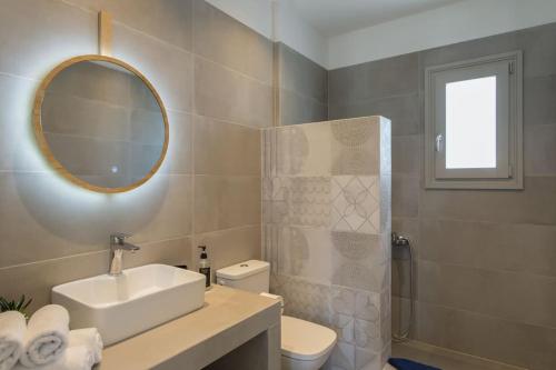 a bathroom with a sink and a toilet and a mirror at Solasta Residence in Márpissa