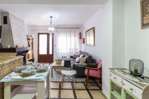 cocina y sala de estar con mesa y sillas en La Casita de Elvira, en Nigüelas
