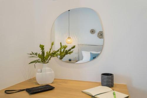 a mirror sitting on a table with a wooden table at Solasta Residence in Márpissa