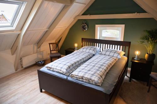 a bedroom with a bed with two pillows on it at Sfeervol verblijf in oude gemeentehuis Eenrum. in Eenrum