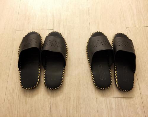 um par de sapatos pretos sentados num chão de madeira em Petercat Hotel Shinchon em Seul