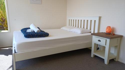 um quarto com uma cama branca e uma mesa de cabeceira em Homestay, millions dollars view at Mount Pleasant em Christchurch