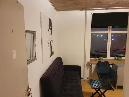 a living room with a couch and a table and a window at Rundvejen Guest House in Aalborg