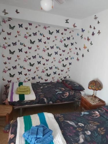 1 dormitorio con 1 cama y mariposas en la pared en Ebro Valley Apartment, en Móra d'Ebre