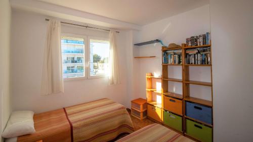 een slaapkamer met een bed en een boekenplank bij Atico en primera línea con vistas al mar - Roquer Marti ALBERT VILLAS in Alcossebre