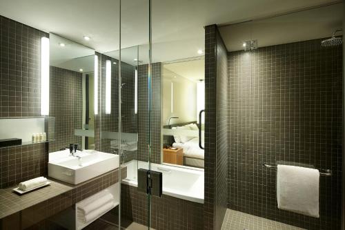 La salle de bains est pourvue d'un lavabo et d'un miroir. dans l'établissement Shilla Stay Jeju Airport, à Jeju