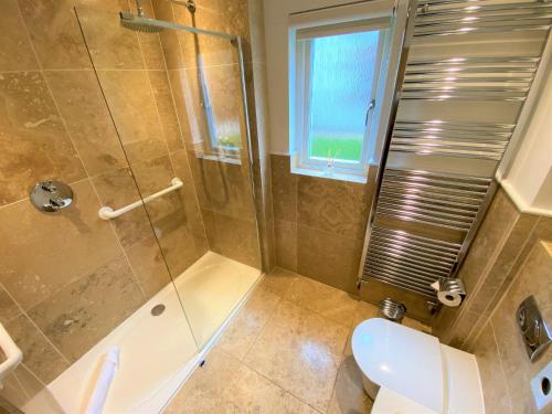 a bathroom with a shower and a toilet and a sink at Trewhiddle Villa 30 in St Austell