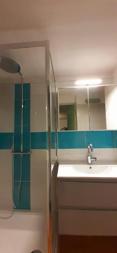 une salle de bain avec un lavabo, une douche et un miroir dans l'établissement BAIE DES ANGES I Joli T2 mezzanine piscine proche plage Richelieu Cap d'Agde, au Cap d'Agde