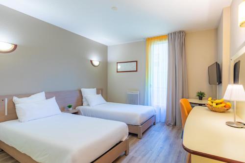 a hotel room with two beds and a tv at Appart'City Confort Nantes Cité des Congrès in Nantes