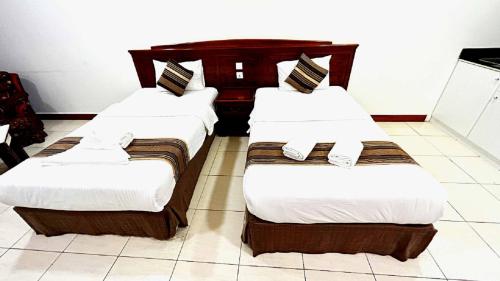 two beds in a hotel room with white and brown at Moon Valley Hotel Apartment - Bur Dubai, Burjuman in Dubai