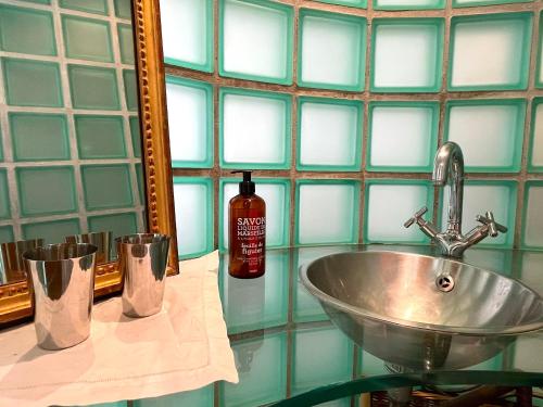 une salle de bain avec un lavabo et un miroir dans l'établissement Le Loft Saint Antoine, à Paris