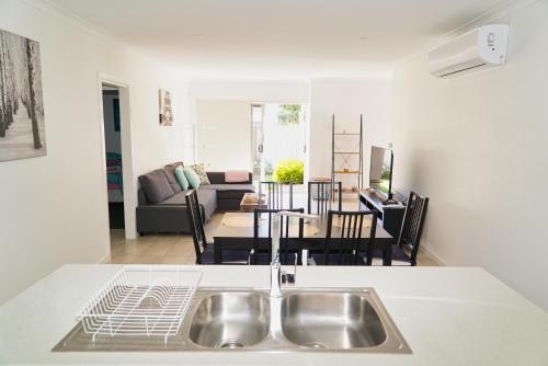 uma cozinha com um lavatório e uma sala de estar em Modern style unit 2 Deer Park em Deer Park