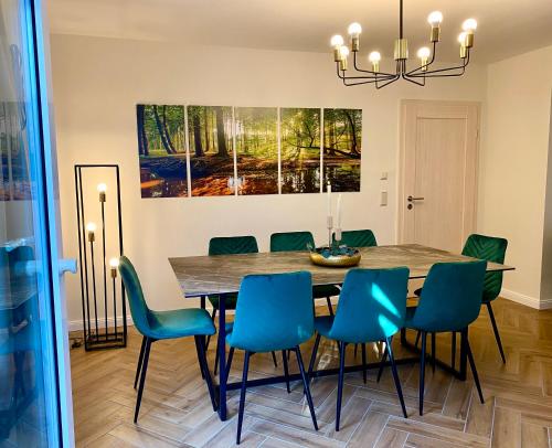 ein Esszimmer mit einem Tisch und blauen Stühlen in der Unterkunft Traumhaus Wernigerode mit Sauna und Kamin in Wernigerode