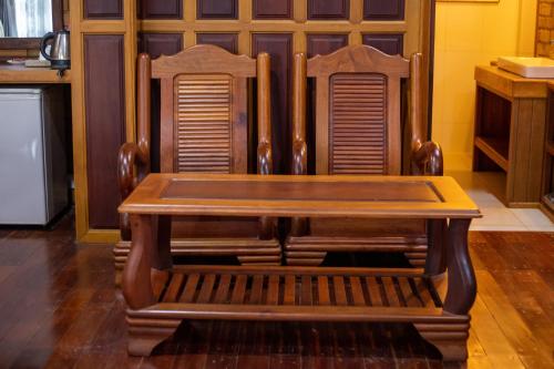 a wooden table and two chairs with a wooden bench at Phum Khmer Resort in Banlung