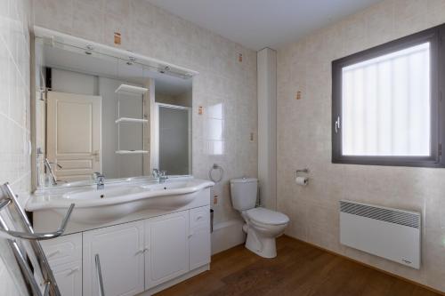 bagno bianco con lavandino e servizi igienici di Patufet - Charmante maison 6 personnes a Fontrabiouse