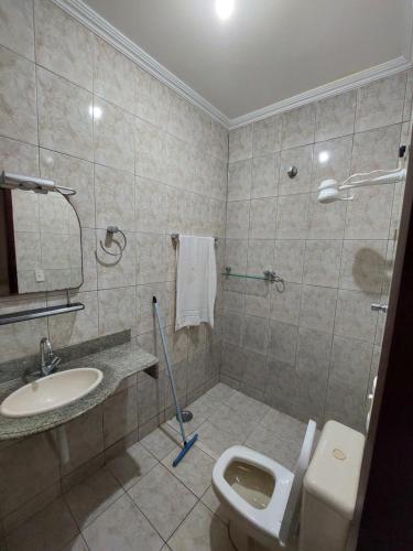 a bathroom with a toilet and a sink at Casas 5 min a pé da praia in Natal