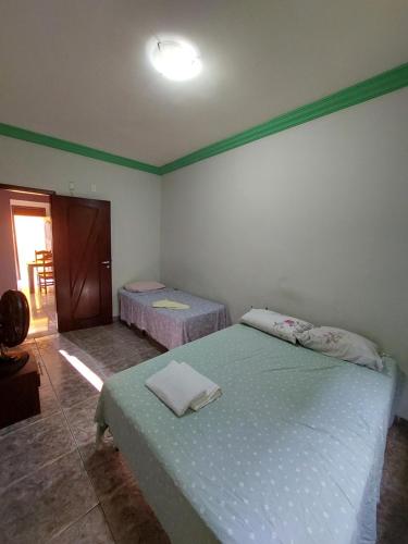 a bedroom with two beds in a room with a door at Casas 5 min a pé da praia in Natal
