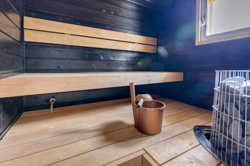 a small bathroom with a bench and a trash can at Lomamökki Johtojuku 1 in Kalajoki