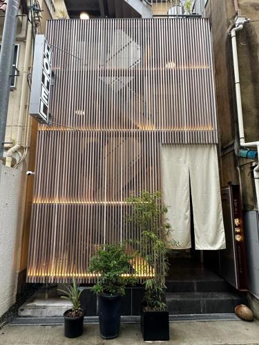 a stairway with potted plants in front of a building at Hotel 草石庵 in Osaka