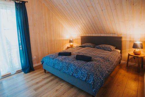 um quarto com uma cama com um edredão azul em Brīvdienu māja Saule em Mersrags