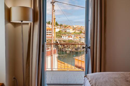 a room with a window with a view of a harbor at Casa das Andorinhas - 1 bedroom apartment sleeps 4 in Câmara de Lobos