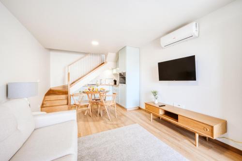 a living room with a couch and a tv on a wall at Casa das Andorinhas - 1 bedroom apartment sleeps 4 in Câmara de Lobos