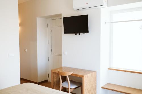a bedroom with a desk and a tv on a wall at Casa das Andorinhas - 1 bedroom apartment sleeps 4 in Câmara de Lobos