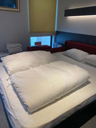 two large white pillows on a bed in a room at Hotel 草石庵 in Osaka
