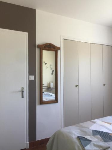 a bedroom with a bed and a mirror on the wall at La Perline, Maison individuelle - 4 à 6 personnes in Le Crestet