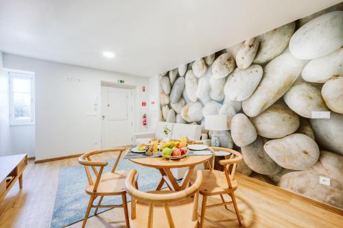 a dining room with a stone wall with a table and chairs at Casa do Calhau - 1 bedroom apartment sleeps 4 in Câmara de Lobos