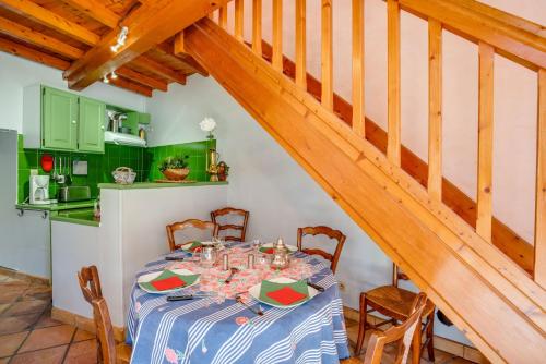 une salle à manger avec une table et un escalier dans l'établissement La Chapelle de Fontmagne - Piscine, tennis et grand parc - Castries, à Castries