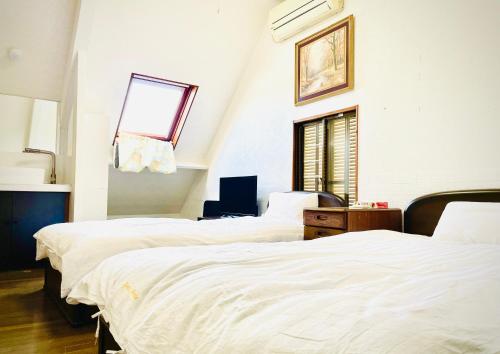 池袋至近完全貸切一軒家 في طوكيو: غرفة نوم بثلاث اسرة ونافذة