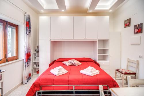um quarto com uma cama vermelha num quarto branco em Casa Lolla em Sorrento