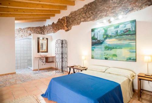 a bedroom with a bed and a painting on the wall at Charming Townhouse 7 PAX WIFI/AIRCON - Ca's Padrí in Llucmajor