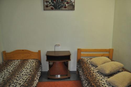 a room with two beds and a table in a room at DayFlat Apartments Kremenchug in Kremenchuk