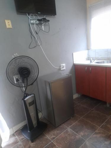 a kitchen with a fan in the corner of a room at Cozy guesthouse springs in Springs