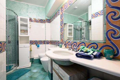 a bathroom with a sink and a toilet and a mirror at Casa Maggio in Vietri sul Mare