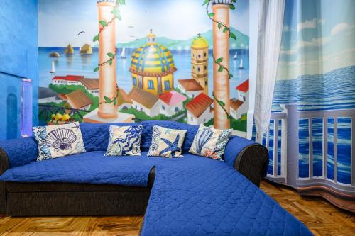 a blue couch in a room with a mural at Casa Maggio in Vietri sul Mare