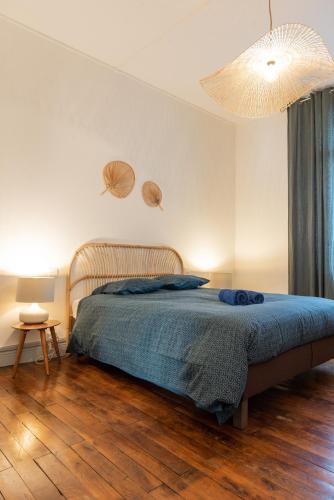 une chambre avec un lit avec une couverture bleue dans l'établissement Le Théodore Bac-Spacieux T2 - Coup de coeur en face de la gare des Bénédictins, à Limoges