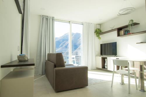 a living room with a chair and a table and a window at Simon's Place Lake View in Nesso