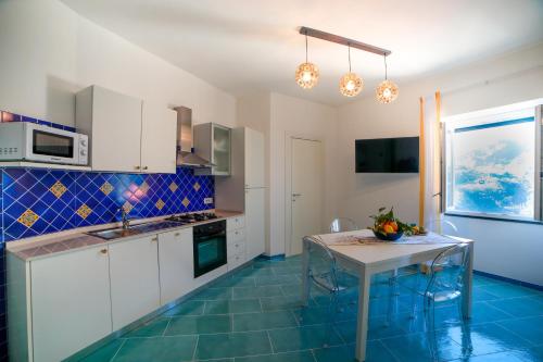 uma cozinha com uma mesa e um piso de azulejo azul em Ncopp' a' Scalinatella em Scala