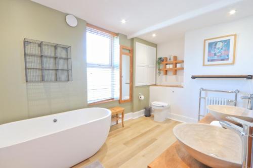 a bathroom with a large white tub and a sink at Terracotta House in Bristol