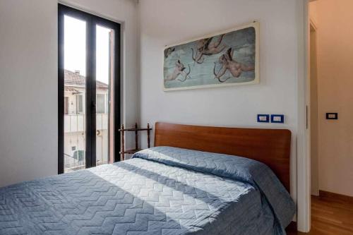 um quarto com uma cama e uma fotografia na parede em L05 Marcelli a due passi dal mare em Marcelli