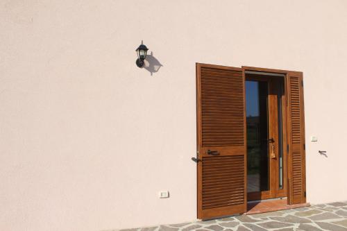 uma porta aberta com uma luz sobre uma parede rosa em Agriturismo Mimosa em Rispescia