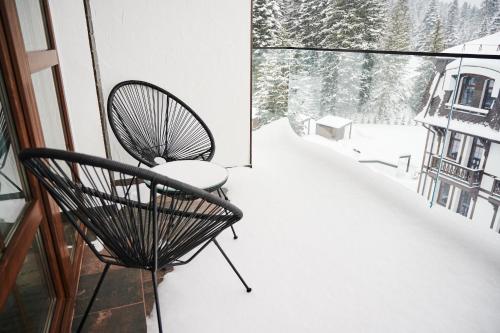a balcony with two chairs in the snow at Crona SPA Karpaty in Skhidnitsa