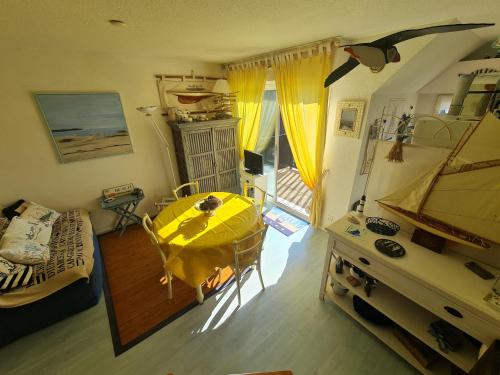 une chambre avec une table et un chiffon de table jaune dans l'établissement REF 012 - Bel appartement pour quatre personnes vue port Crouesty ARZON, à Arzon